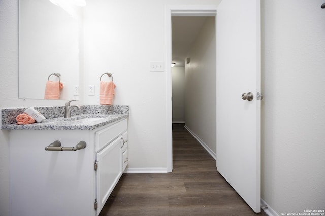 bathroom featuring vanity, baseboards, and wood finished floors