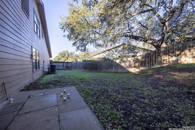 view of yard featuring a patio area, a fenced backyard, and central AC