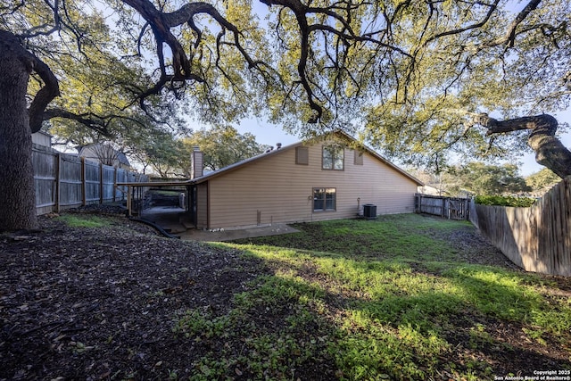 back of house with a yard, cooling unit, and a fenced backyard