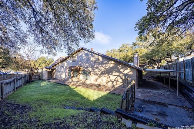 exterior space with a patio area, a fenced backyard, a chimney, and a lawn