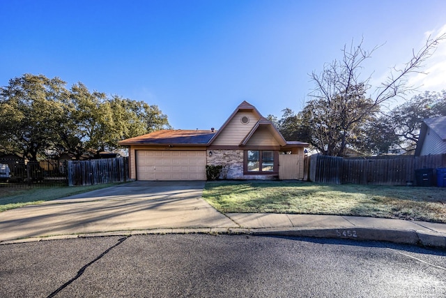 view of front of house featuring driveway, an attached garage, fence, and a front lawn