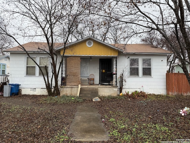 bungalow with a porch, crawl space, roof with shingles, and fence