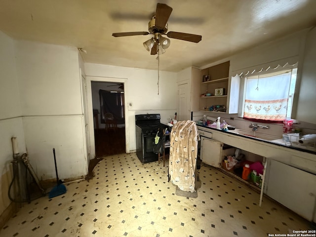 kitchen featuring a ceiling fan, black range, light floors, open shelves, and a sink