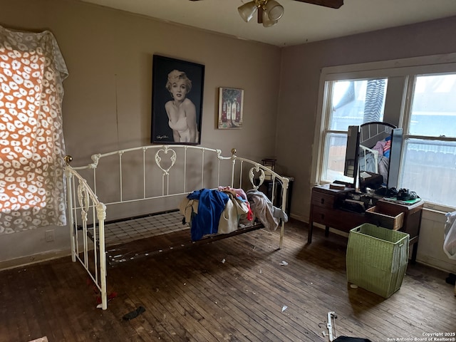 bedroom with ceiling fan, baseboards, and wood finished floors