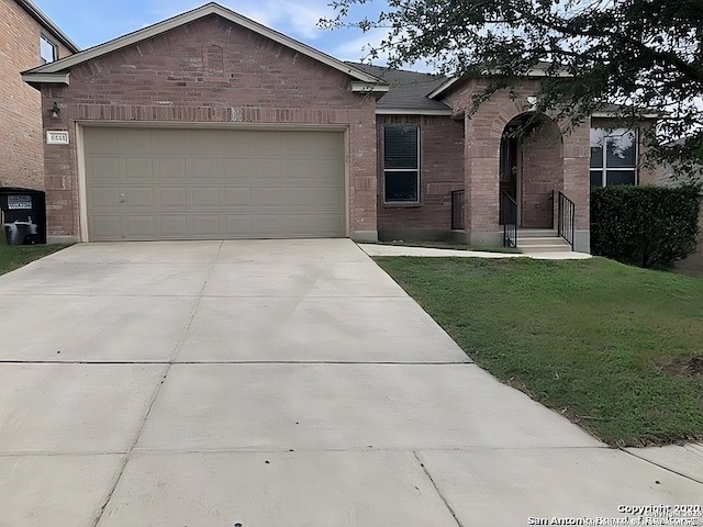 single story home with a front yard, brick siding, driveway, and an attached garage