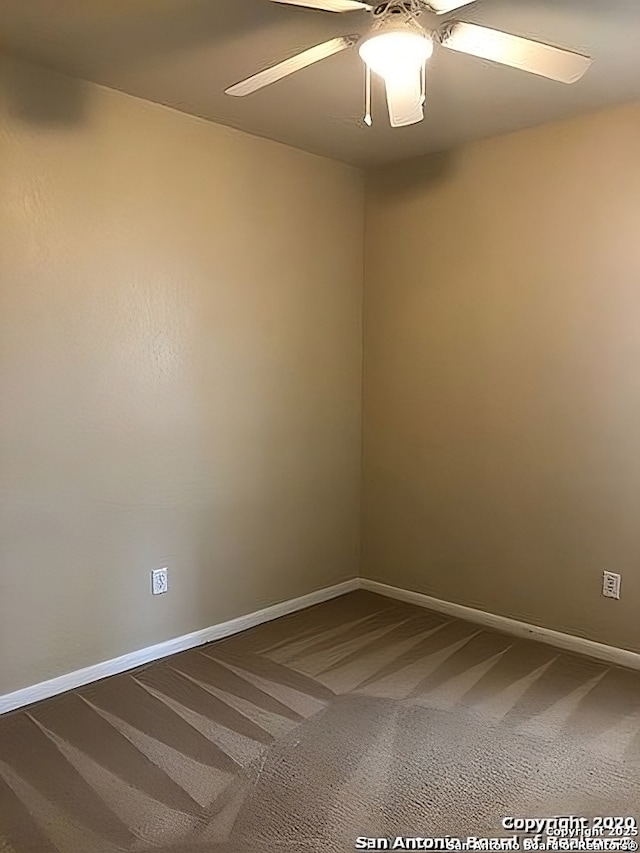 carpeted spare room with ceiling fan and baseboards