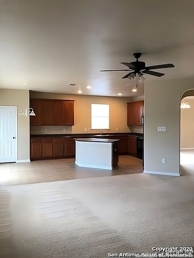 kitchen featuring baseboards, ceiling fan, dark countertops, and brown cabinets