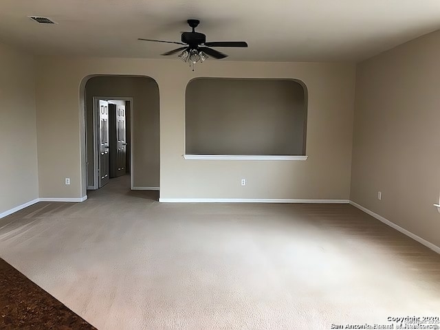 unfurnished room featuring visible vents, ceiling fan, and baseboards