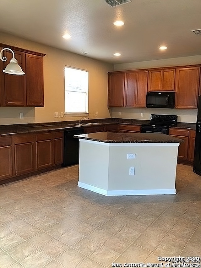 kitchen with dark countertops, recessed lighting, visible vents, brown cabinetry, and black appliances