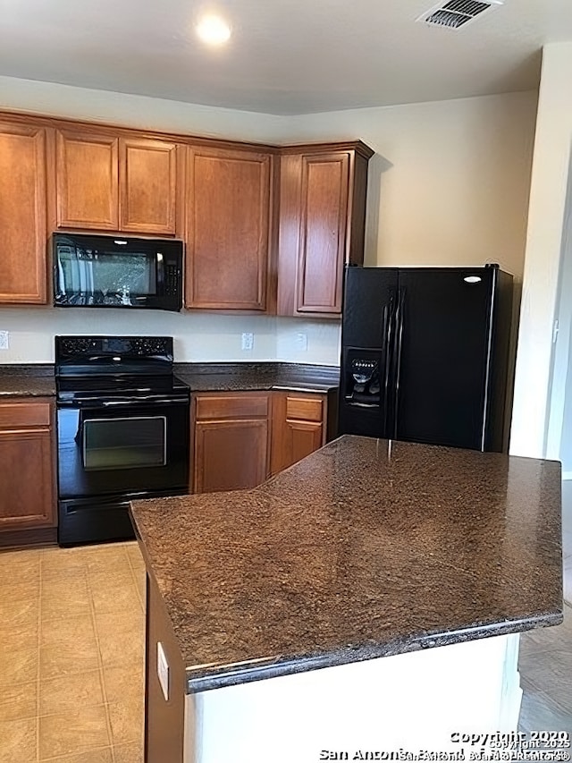 kitchen with brown cabinetry and black appliances