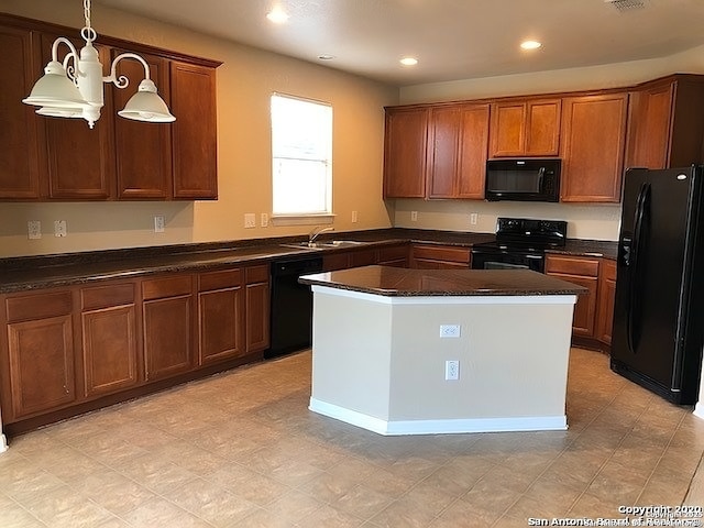 kitchen featuring black appliances, dark countertops, decorative light fixtures, and brown cabinets