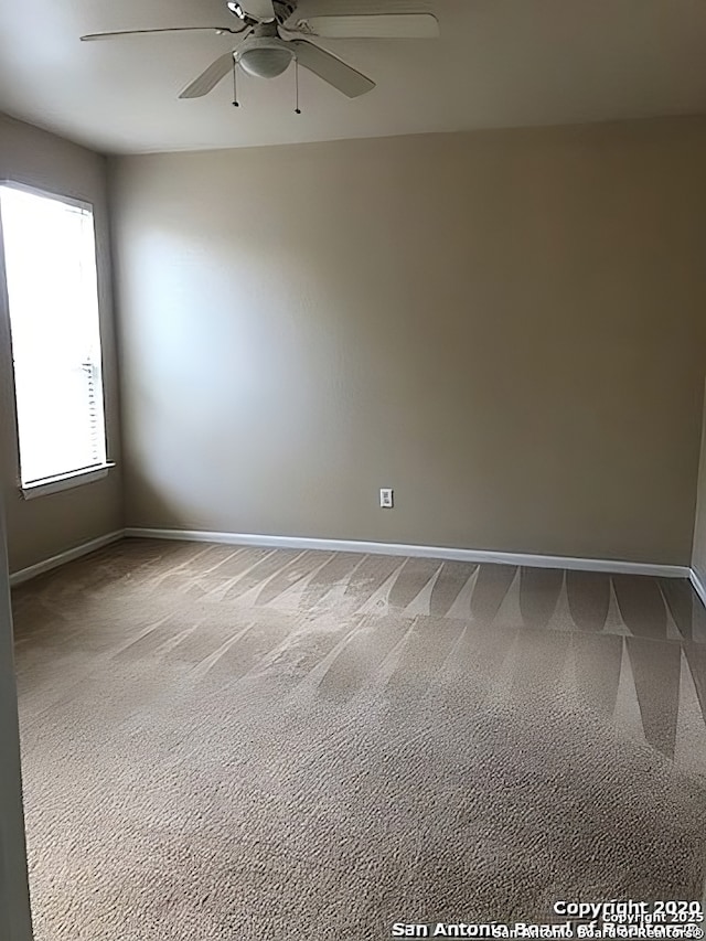 carpeted empty room with ceiling fan and baseboards