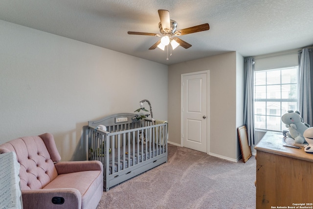 bedroom with light colored carpet, ceiling fan, a textured ceiling, and baseboards