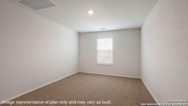 empty room featuring carpet, visible vents, and baseboards