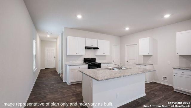 kitchen with under cabinet range hood, a sink, white cabinets, black range oven, and an island with sink