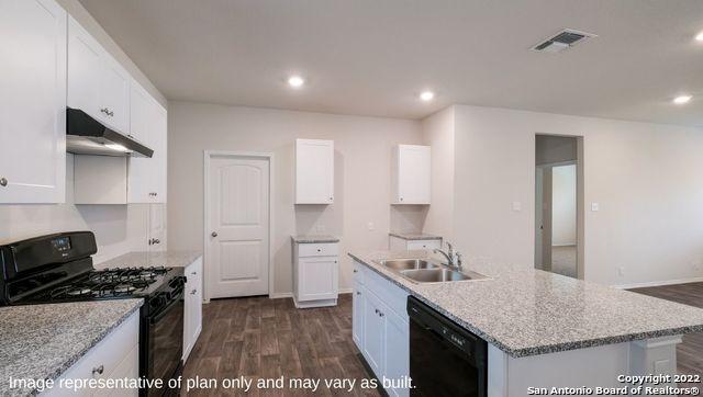 kitchen featuring under cabinet range hood, a sink, white cabinets, black appliances, and a center island with sink