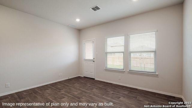 empty room with dark wood-type flooring, recessed lighting, visible vents, and baseboards