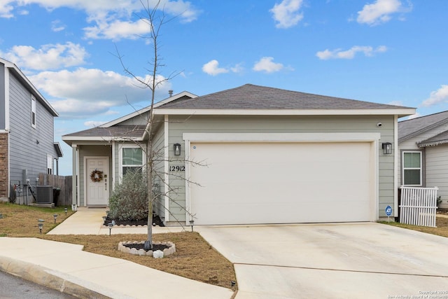 ranch-style home featuring a garage, central AC, fence, and driveway