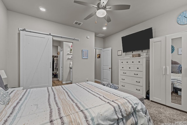 bedroom with light carpet, a barn door, visible vents, a ceiling fan, and recessed lighting