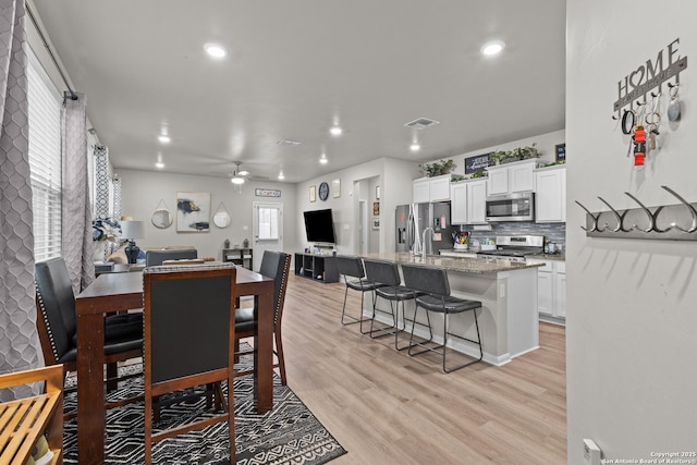 dining area featuring a ceiling fan, recessed lighting, and light wood finished floors