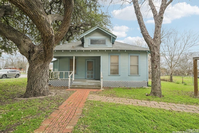 bungalow-style house featuring covered porch and a front lawn