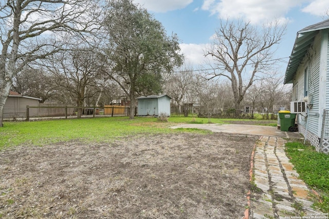 view of yard featuring an outbuilding, fence, and a storage unit