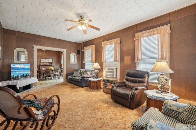 living area featuring ceiling fan, carpet floors, wood walls, and cooling unit