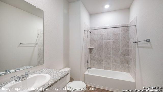 bathroom featuring tub / shower combination, vanity, and toilet