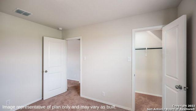 unfurnished bedroom featuring light carpet, baseboards, visible vents, and a closet