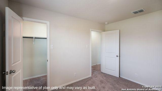 unfurnished bedroom with light carpet, baseboards, visible vents, and a closet