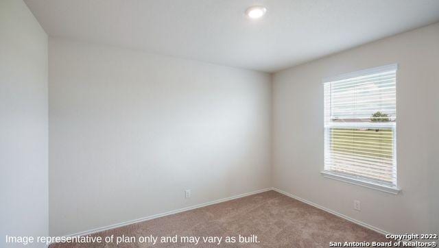 unfurnished room with light carpet and baseboards