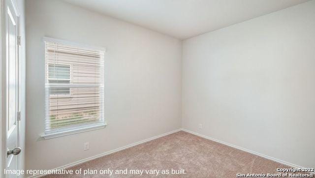 unfurnished room with light carpet and baseboards