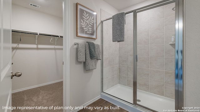 full bath featuring visible vents, a spacious closet, baseboards, and tiled shower