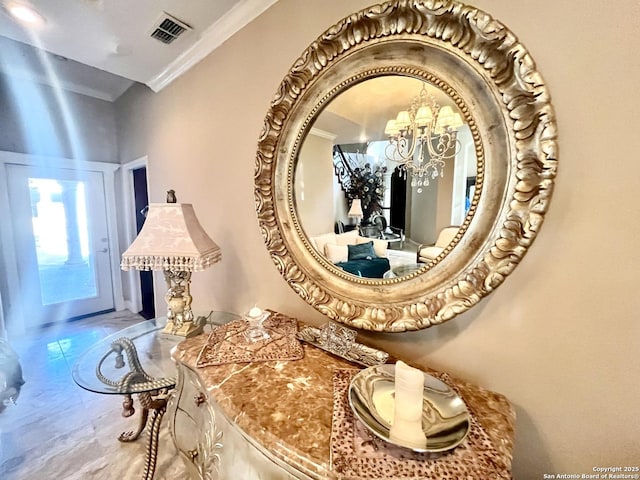 details featuring ornamental molding, visible vents, and a notable chandelier