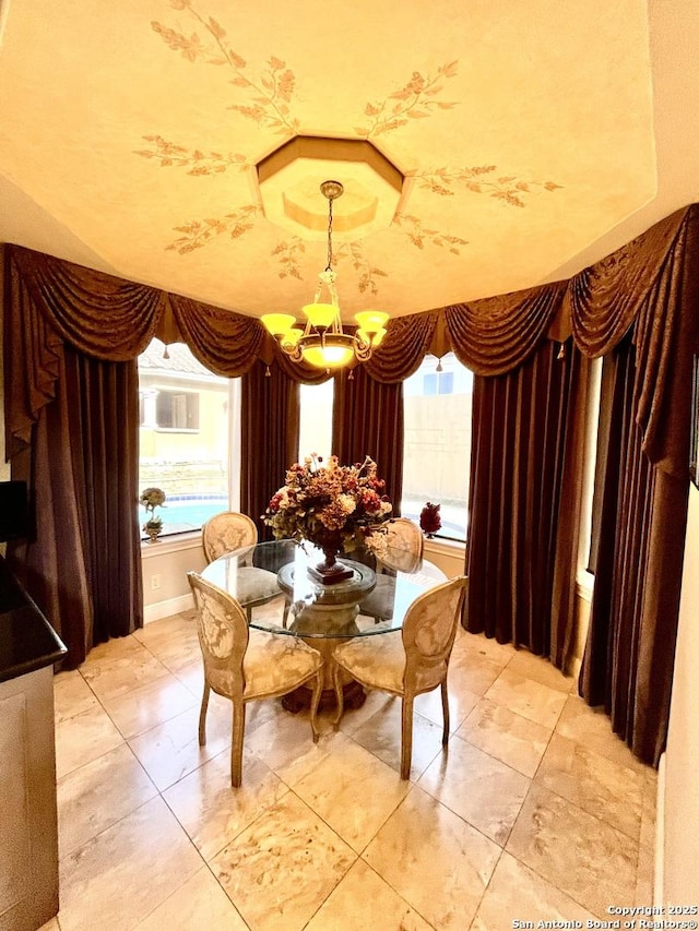 dining room with a tray ceiling and a notable chandelier