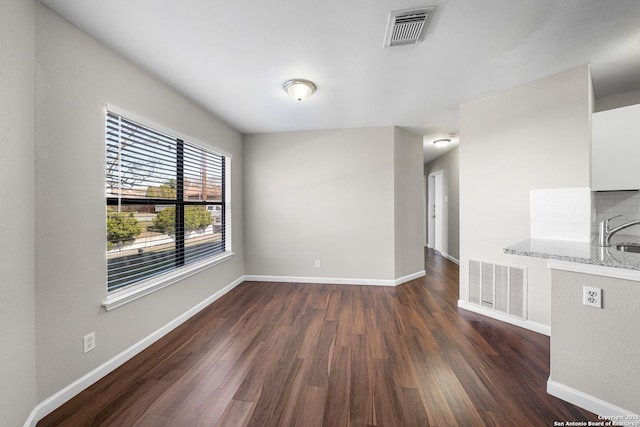 interior space featuring dark wood-style floors, visible vents, and baseboards