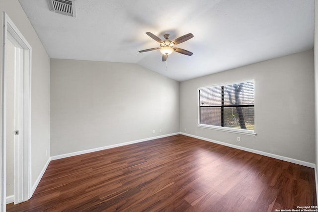 empty room with lofted ceiling, dark wood finished floors, visible vents, and baseboards