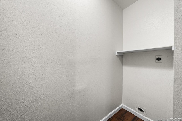 clothes washing area with laundry area, electric dryer hookup, baseboards, and wood finished floors