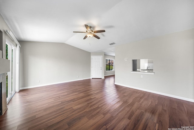 unfurnished living room with dark wood-style flooring, a ceiling fan, a glass covered fireplace, vaulted ceiling, and baseboards