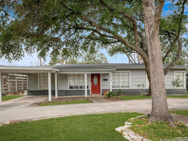 view of front of property with concrete driveway, brick siding, and an attached carport