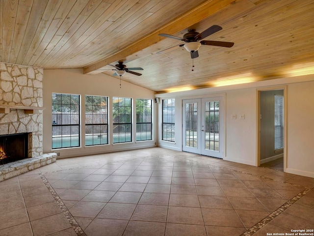 unfurnished living room with a fireplace, lofted ceiling with beams, wood ceiling, light tile patterned flooring, and baseboards