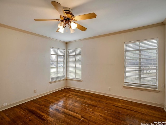 empty room with ornamental molding, dark wood-style flooring, baseboards, and a ceiling fan