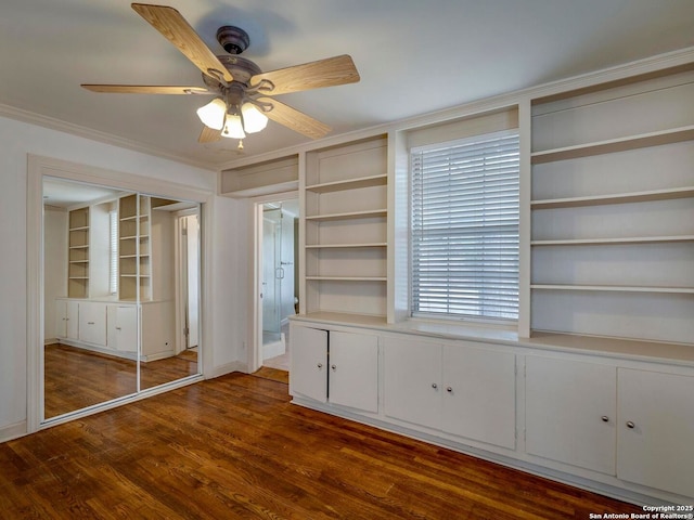 unfurnished bedroom with crown molding, ceiling fan, and dark wood-style flooring