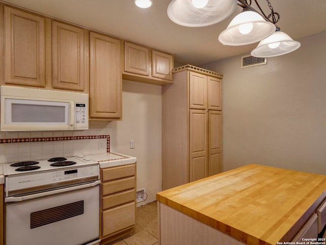 kitchen with white appliances, visible vents, hanging light fixtures, wooden counters, and backsplash