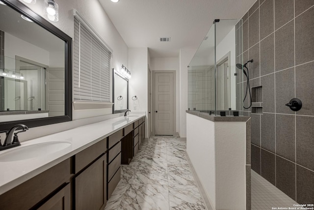 full bathroom featuring a walk in shower, marble finish floor, double vanity, and a sink