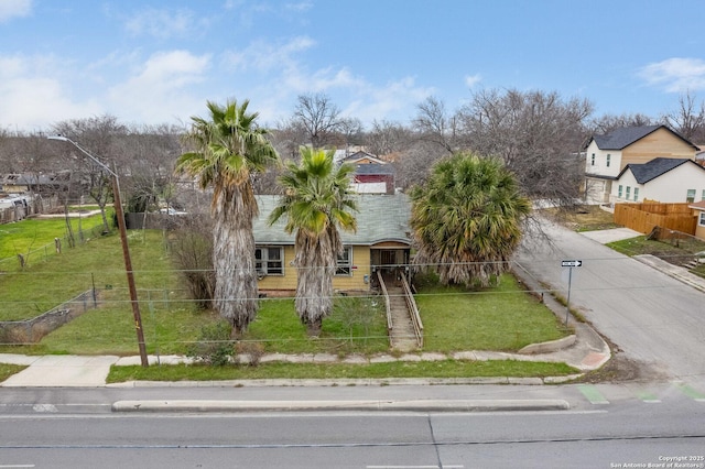 view of front of house featuring a fenced front yard, a front yard, and a residential view