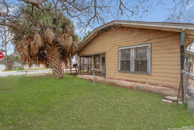 view of property exterior featuring a yard, crawl space, and fence