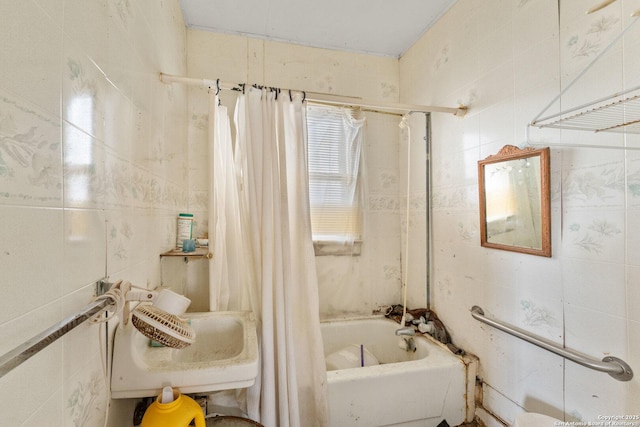 bathroom with shower / bath combo and tile walls