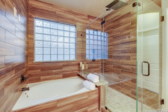 full bathroom featuring a stall shower and a bath