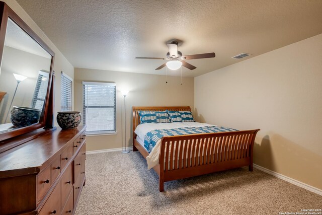 bedroom featuring light carpet, baseboards, visible vents, ceiling fan, and a textured ceiling